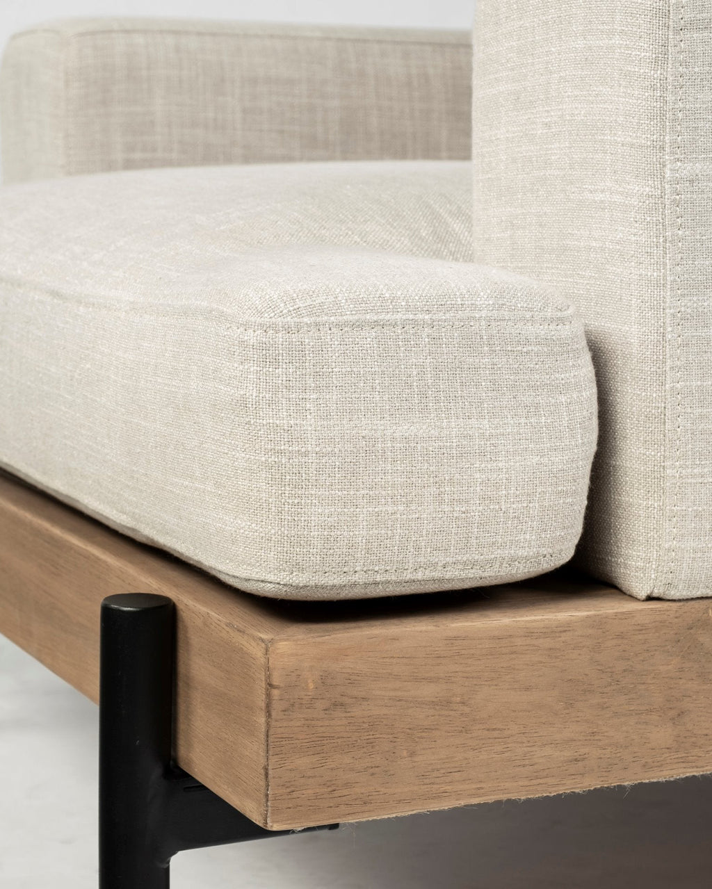 Close-up of a beige upholstered chair with wooden legs on a neutral background