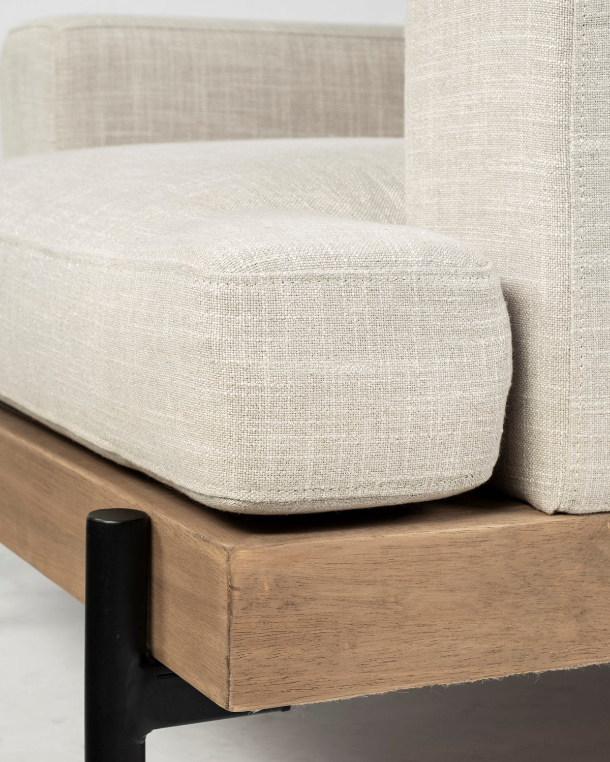 Close-up of a beige upholstered chair with wooden legs on a neutral background