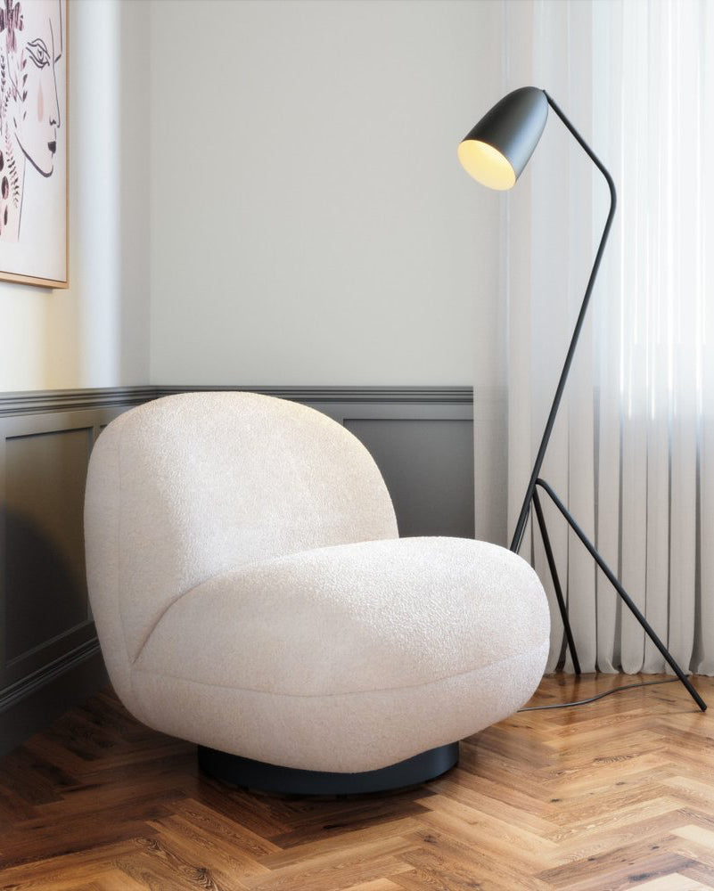 Beige armchair in a room with a floor lamp and window blinds.