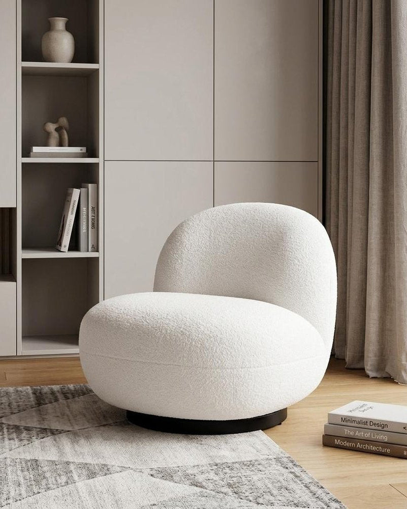 Modern white chair in a minimalistic room with shelves and books.