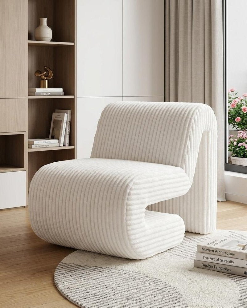Modern white chair in a stylish living room with bookshelf and decor.