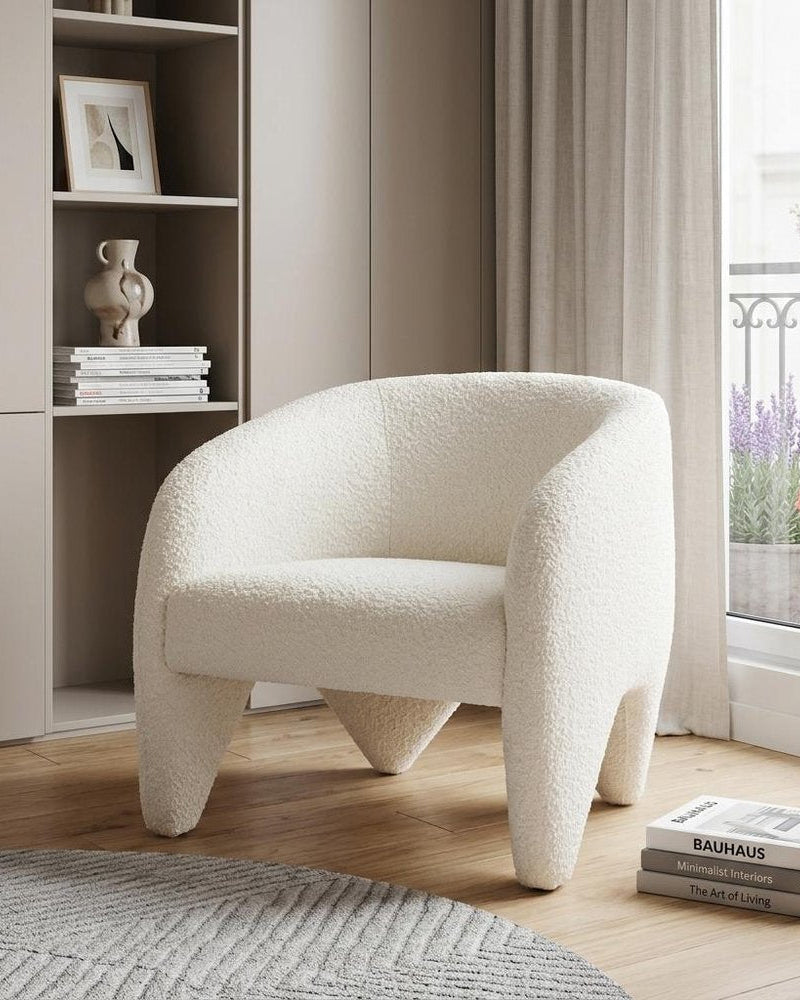 White textured armchair in a modern living room with a bookshelf and window.