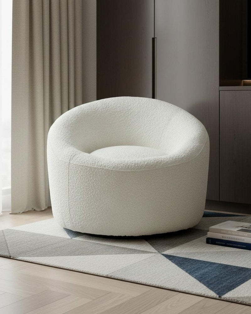 White textured armchair in a modern living room setting with a rug and books.