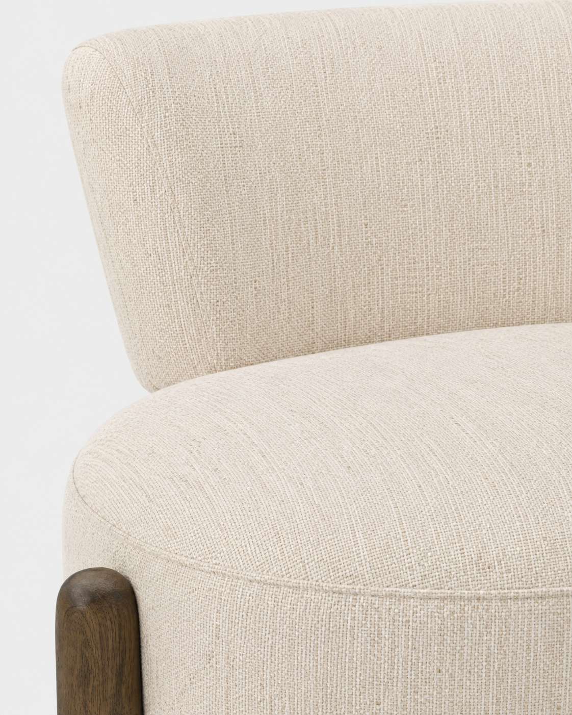 Close-up of a modern upholstered chair or sofa arm and seat in a warm off-white textured fabric, with a dark wood leg visible against a clean white background.