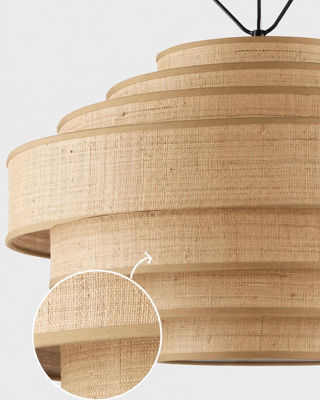 A close-up of a tiered pendant light shade made from woven natural fiber, with a circular inset showing the detailed texture of the material.